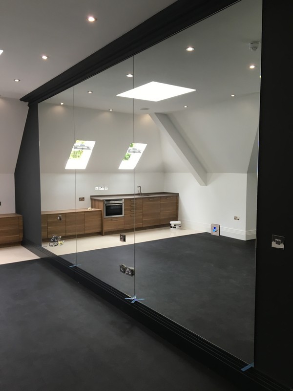 Frameless glass partition in loft conversion by Stamford Hill glaziers