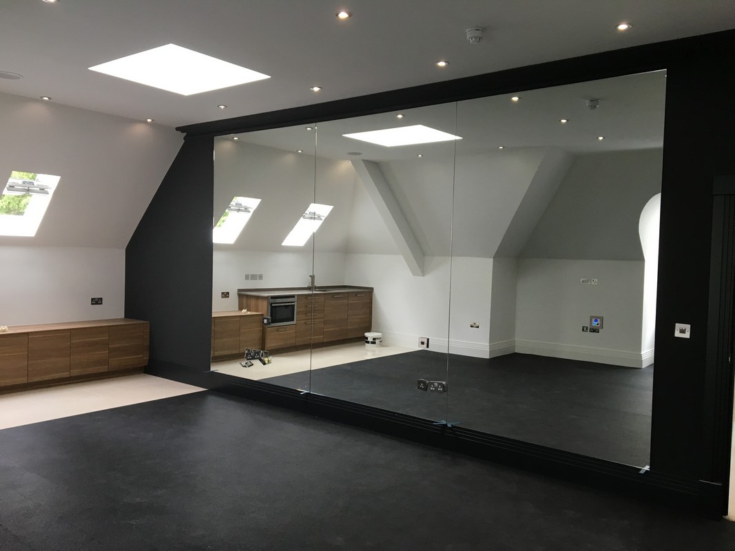 Frameless glass wall dividing loft conversion in Stamford Hill